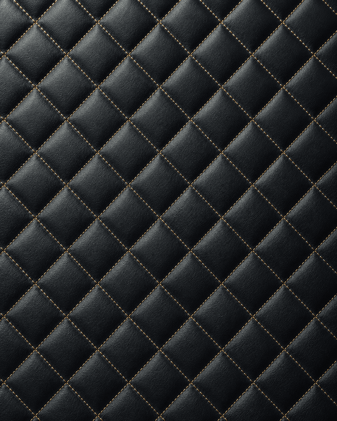 Close-up of black quilted leather interior lining accented with gold diamond stitching