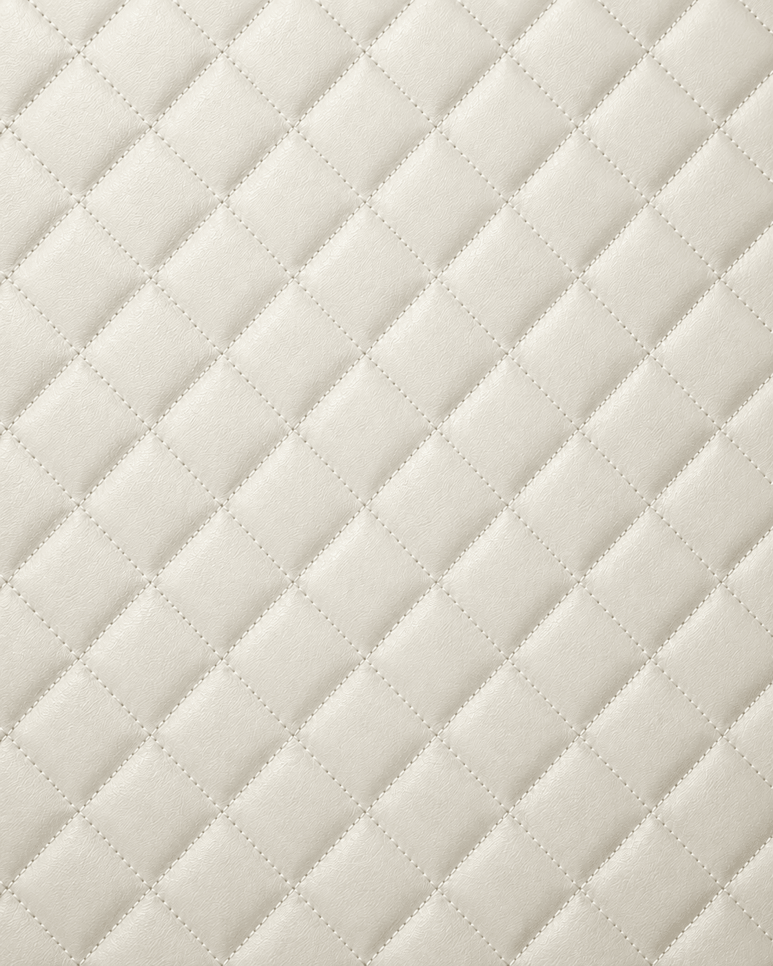 Close-up of warm cream quilted leather interior lining with diamond stitching