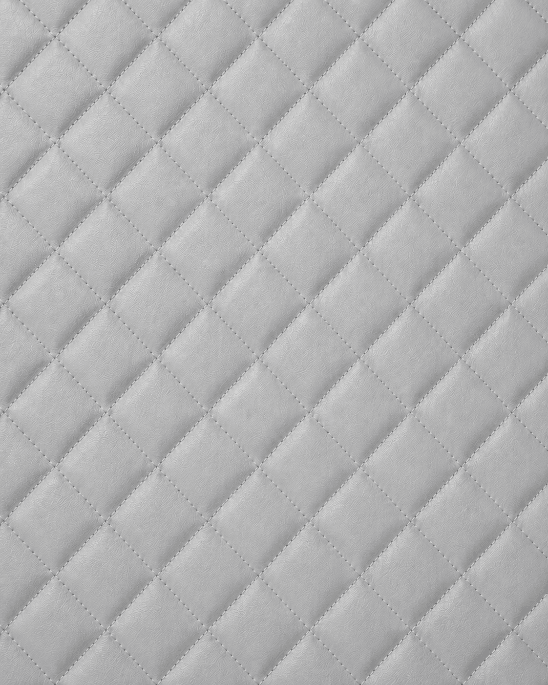 Close-up of soft light gray quilted leather interior lining with diamond stitching